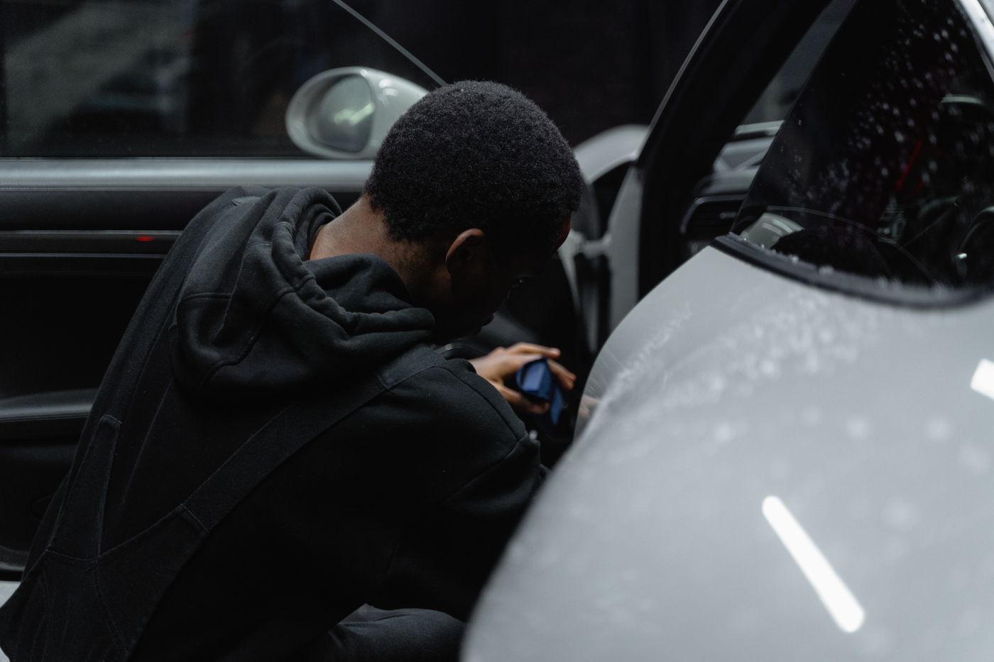 A detailer working inside a car