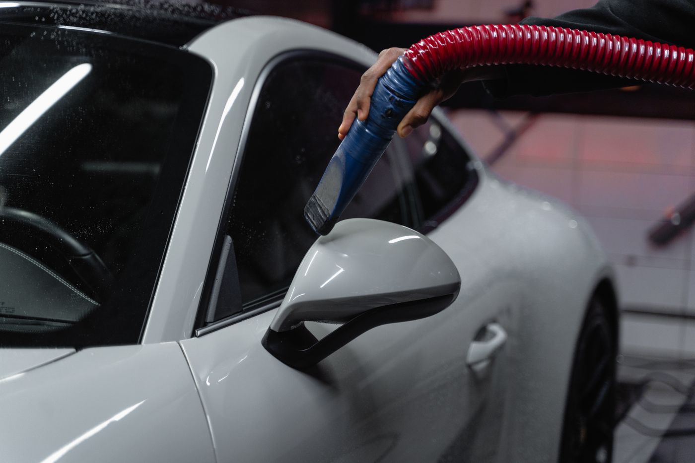 A white car being cleaned in a detailing bay
